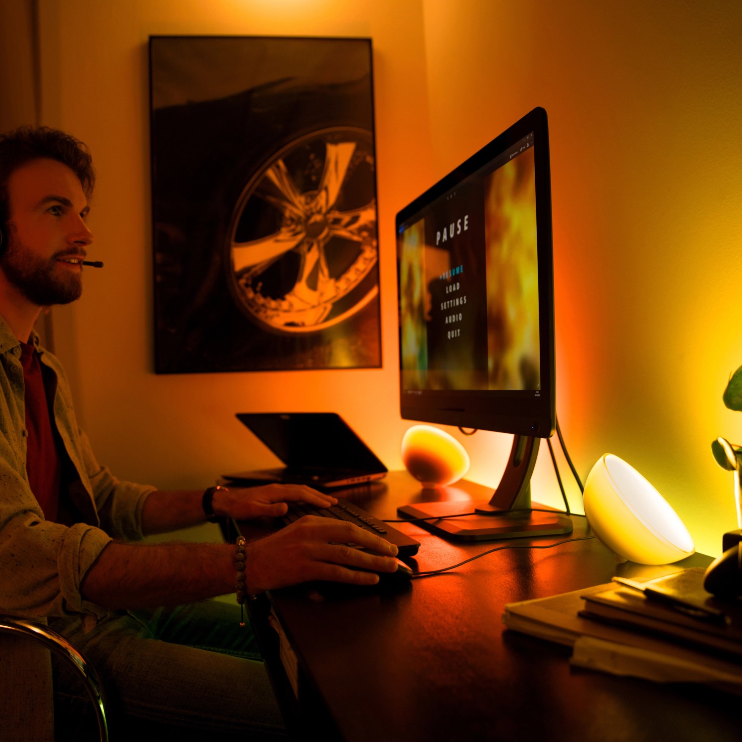 Szene mit Philips Hue Go Tischlampe: Gamer am PC mit stimmungsvoller Beleuchtung.