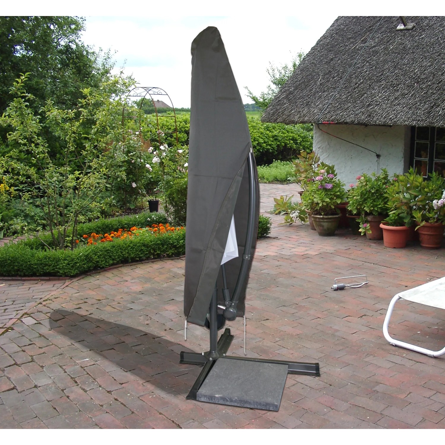Graue Acamp Schutzhülle für einen Alu-Ampelschirm bis 300 cm im Garten.