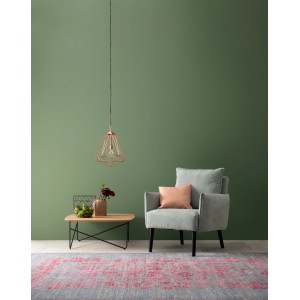 Wohnraum in Ausgeglichenem Piniengrün: Matte Wandfarbe mit Sessel, Teppich und Tisch.