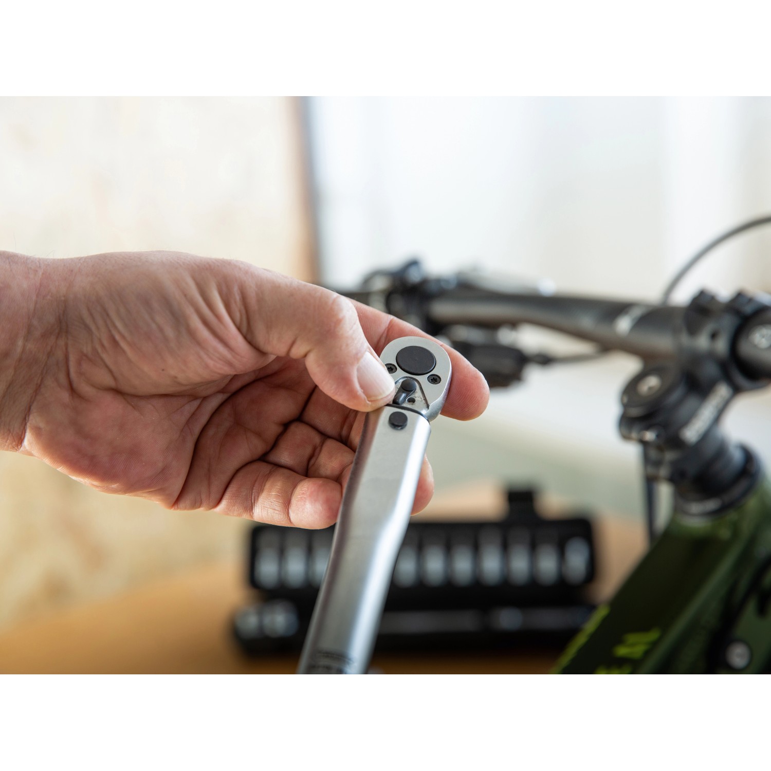Hand justiert LUX Drehmomentschlüssel-Set vor Fahrrad. Schlüssel & Abzieher.