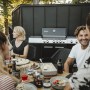 Enders Gasgrill Uniq Pro 3 IK Cruster in Schwarz-Edelstahl mit Personen beim Grillen.