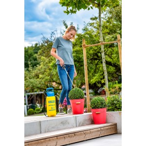 Frau nutzt Gloria Sprühlanze 270° Anti-Zünsler mit Drucksprühgerät zur Gartenpflege.