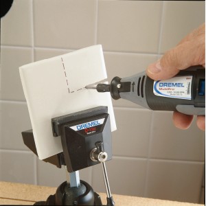 Dremel Spiralfräser 562 beim Fräsen einer Keramikfliese, eingespannt in einen Schraubstock.