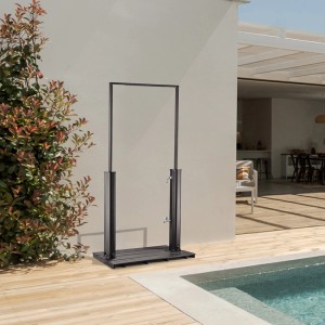 Home Deluxe Solardusche PAROS Anthrazit mit Bodenplatte neben Pool.