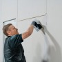 Handwerker beim Auftragen von Knauf Uniflott Finish Feinspachtel auf eine Gipskartonwand.