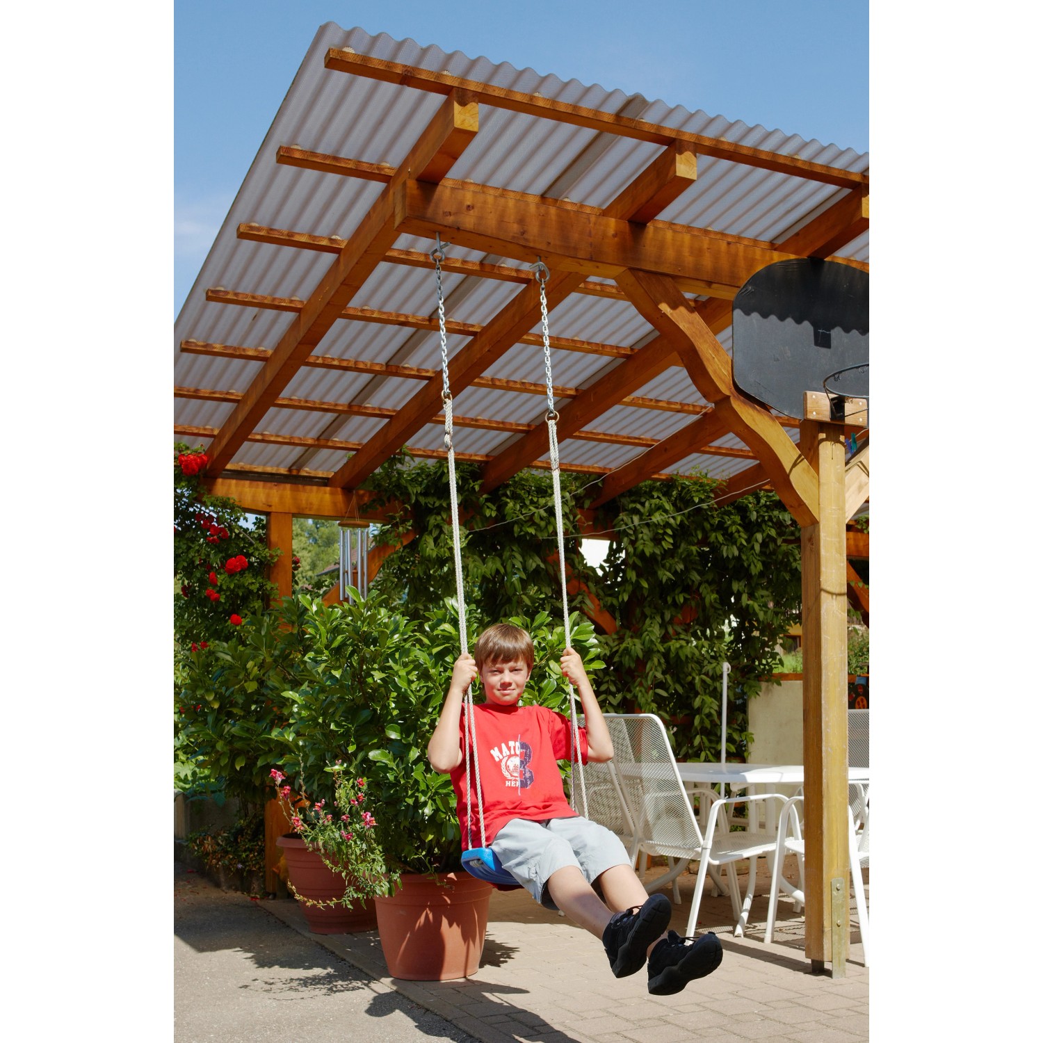 Bronze Acryl-Profilplatte Sinus 76/18 Wabe als Terrassenüberdachung mit spielendem Kind auf Schaukel.