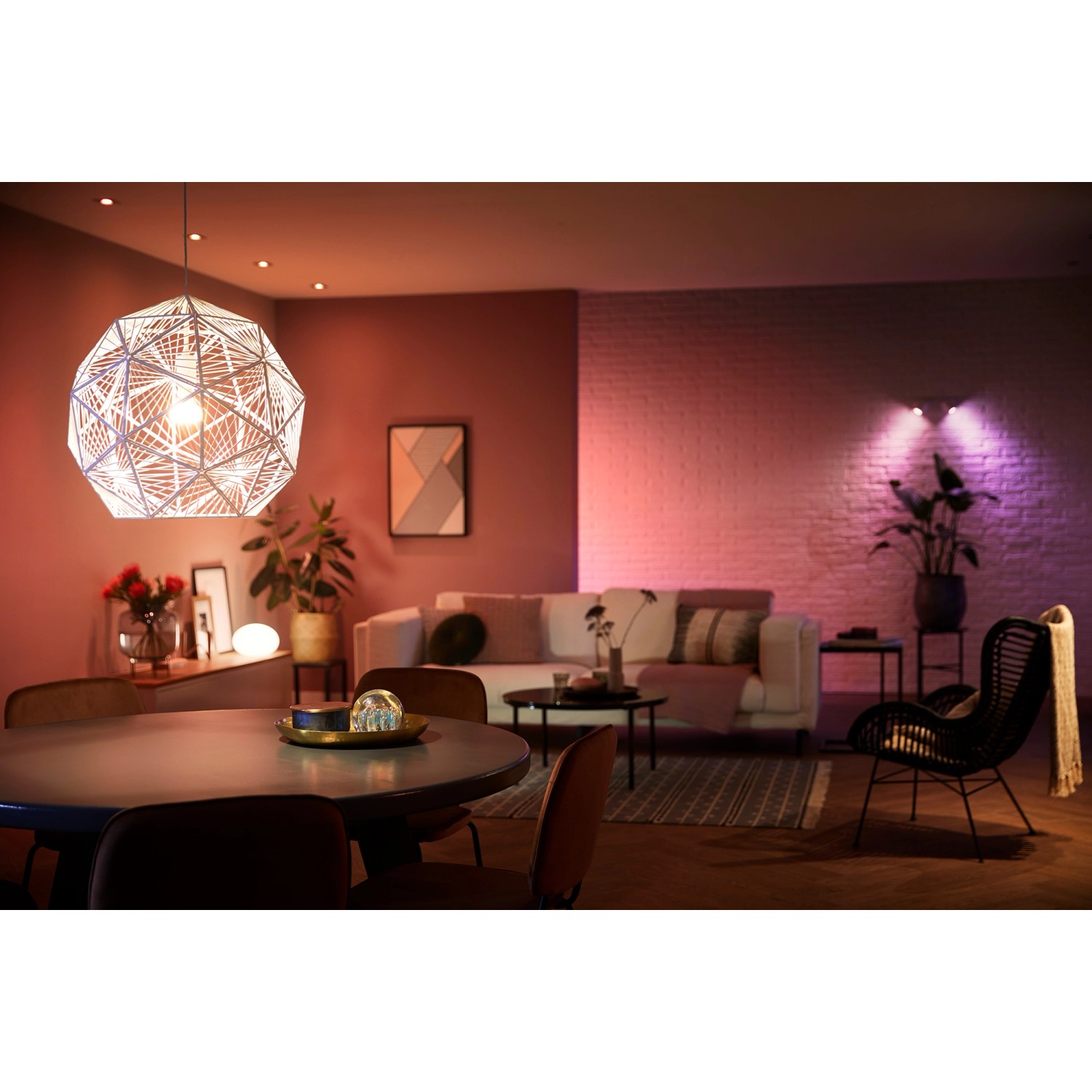 Philips Hue E27 Lampe im Wohnzimmer mit farbiger Beleuchtung.