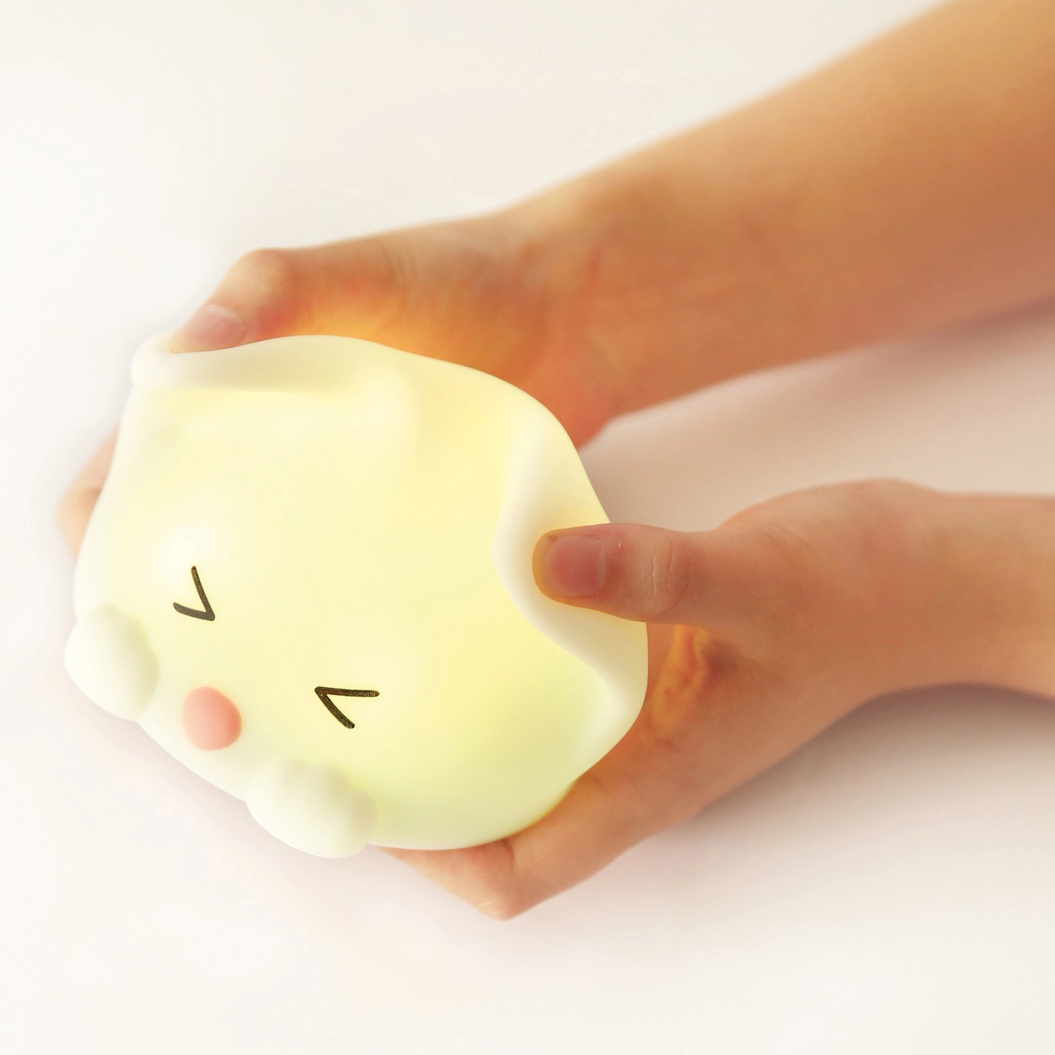 Dimmbares LED Kinder-Nachtlicht Catty Cat mit Soundeffekt in Händen.