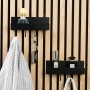Schwarzes DenPanels Regal mit 4 Stiften an Akustikpaneel mit Deko und Jacke.