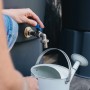 Regentonnenanschluss aus Messing (3/4 Zoll) mit Wasserhahn und Gießkanne in Nutzung.