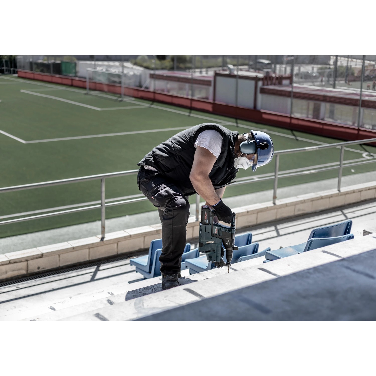 Mann bohrt mit Bosch Expert Hammerbohrer SDS Plus-7X ein Loch in Beton.