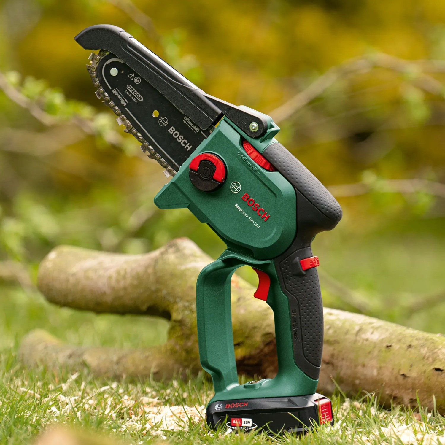Bosch Akku-Gehölzschneider EasyChain 18V-15-7 mit Akku und Ladegerät auf Rasen.
