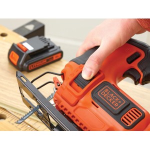 Black+Decker Akku-Stichsäge BDCJS18 in Aktion, mit Akku im Hintergrund.