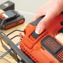 Black+Decker Akku-Stichsäge BDCJS18 in Aktion, mit Akku im Hintergrund.