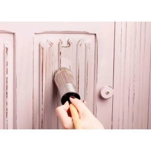 Auftragen von Rust-Oleum Möbelwachs Dunkel matt auf ein rosa Möbelstück mit Kreidefarbe.