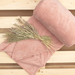 Rosa Kuscheldecke Softy (150x200 cm) von JBY Creation, gerollt und gefaltet mit Dekoration.