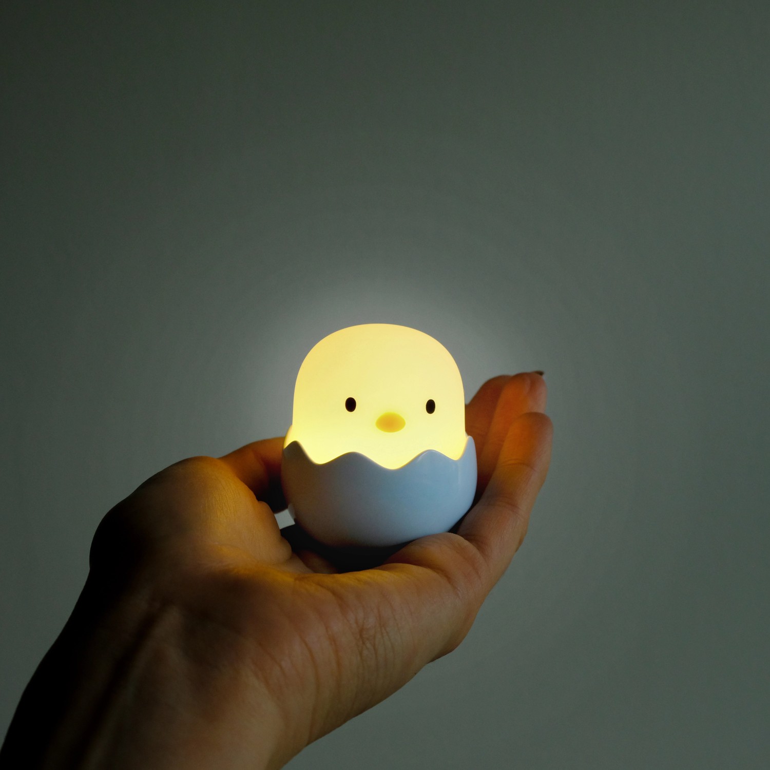 Dimmbares LED Nachtlicht Baby Eggy im 3er-Set in Hand gehalten. Küken-Design.