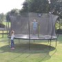 Rosa EXIT Silhouette Gartentrampolin (D427cm) mit Sicherheitsnetz und zwei Kindern im Garten.
