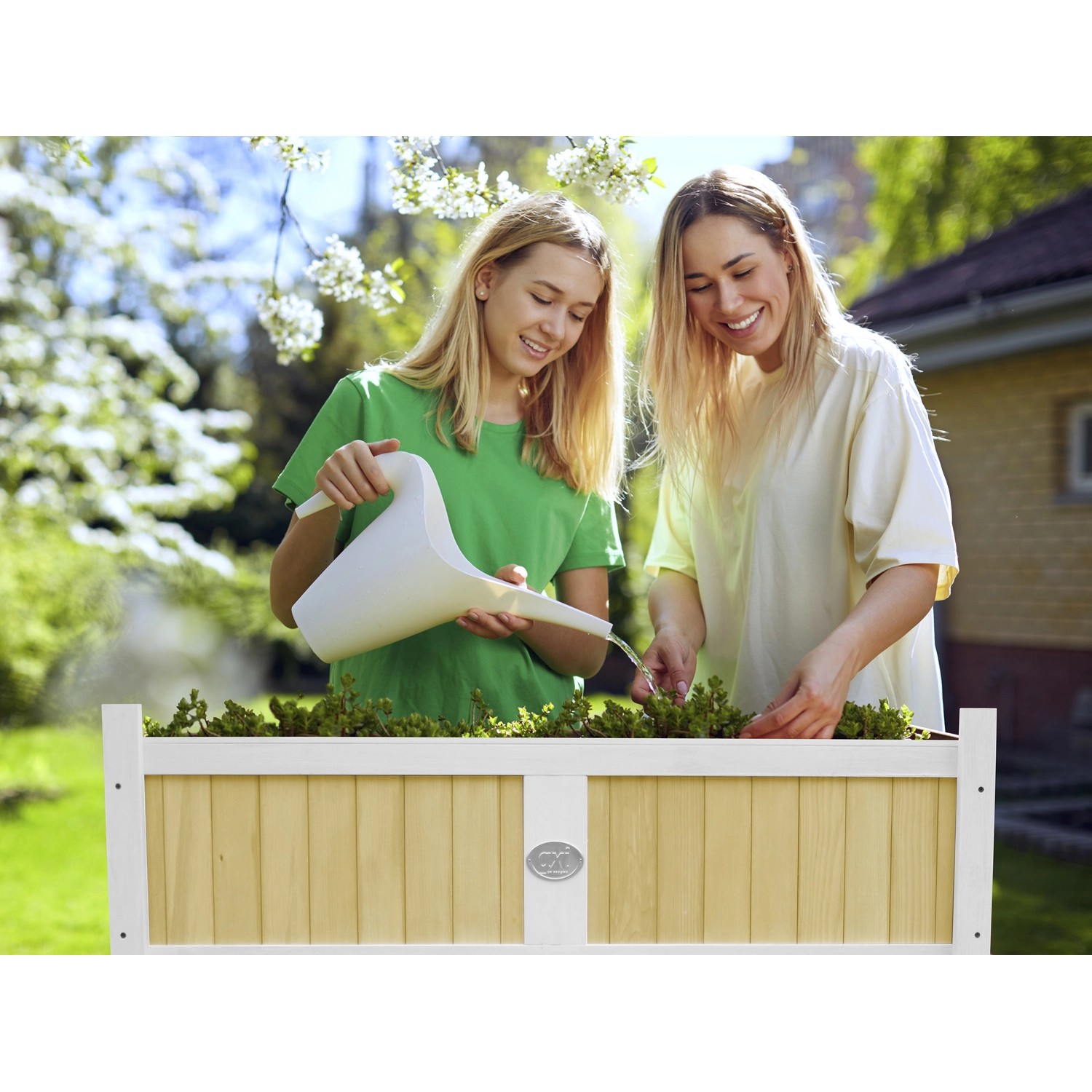 Axi Hochbeet, braun-weiß, 120x54x90cm. Zwei Frauen gießen Pflanzen im Beet.