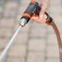 Hand hält Gardena Premium Reinigungsspritze mit Wasserstrahl. Gartenspritze für kraftvolle Reinigungsarbeiten.