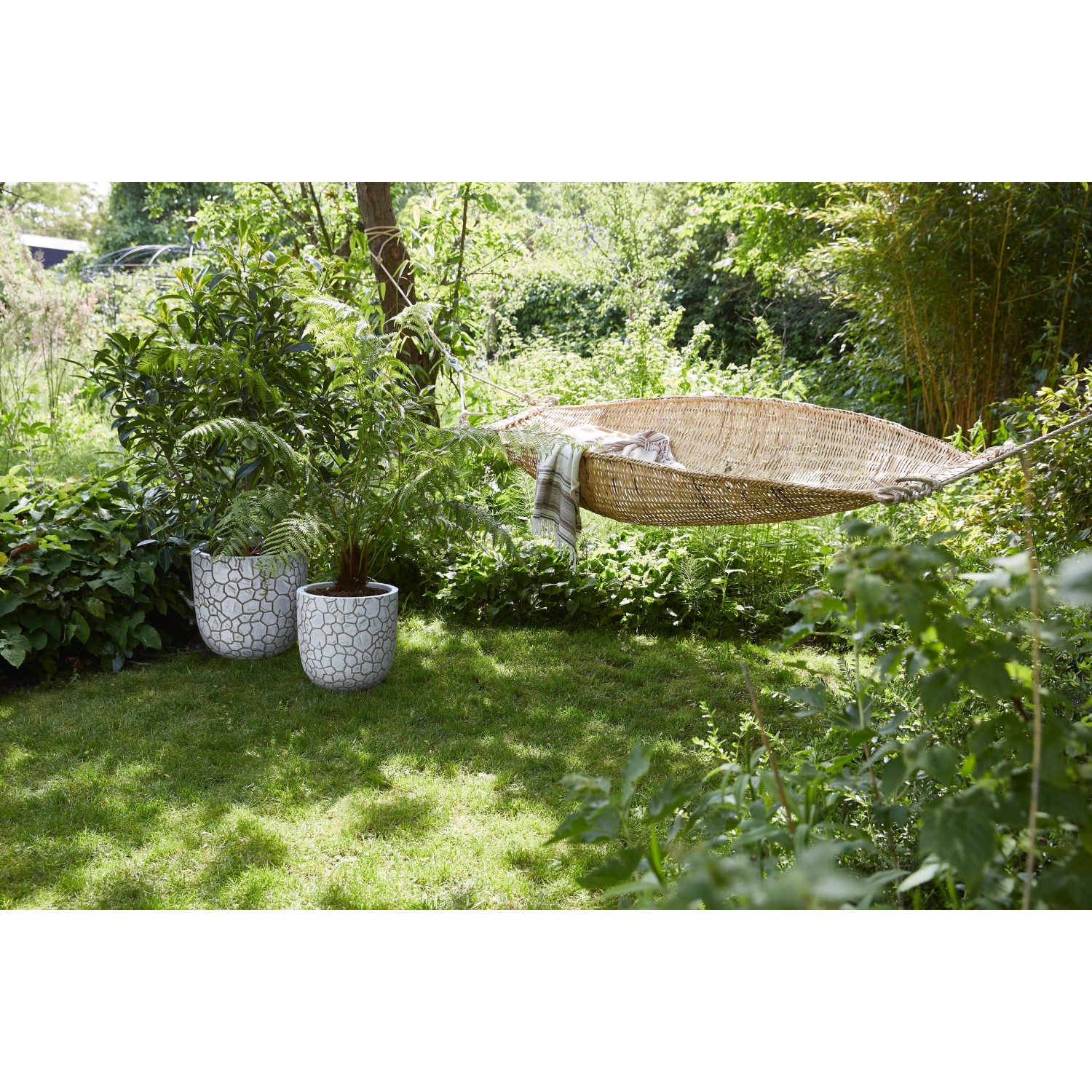 Capi Pflanztopf Clay Kugel, elfenbeinfarben, Ø 43cm, im Garten mit Hängematte.