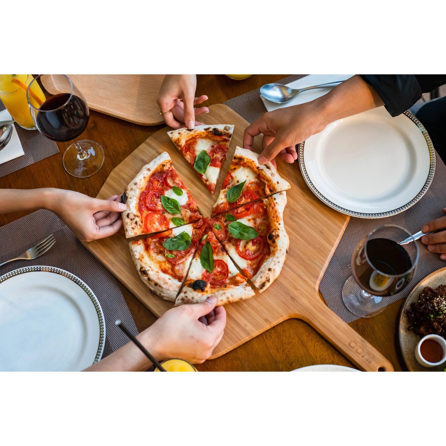 Ooni Pizzaschieber aus Bambus mit Pizza, ideal zum Servieren. Grillutensil für Pizzaöfen.