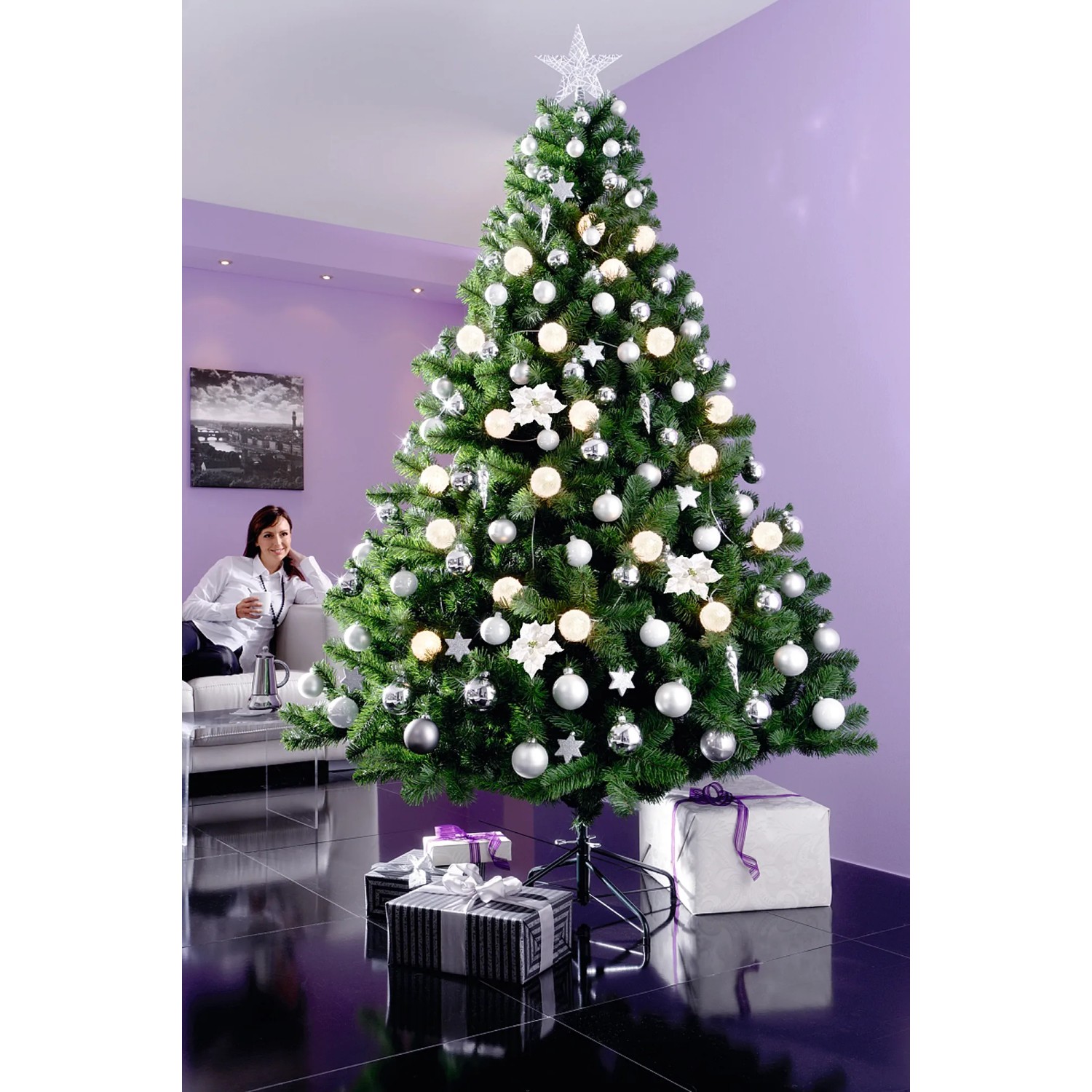 Geschmückter, künstlicher Weihnachtsbaum Colorado, 90 cm hoch, mit silbernen Kugeln und Lichtern im Wohnzimmer.