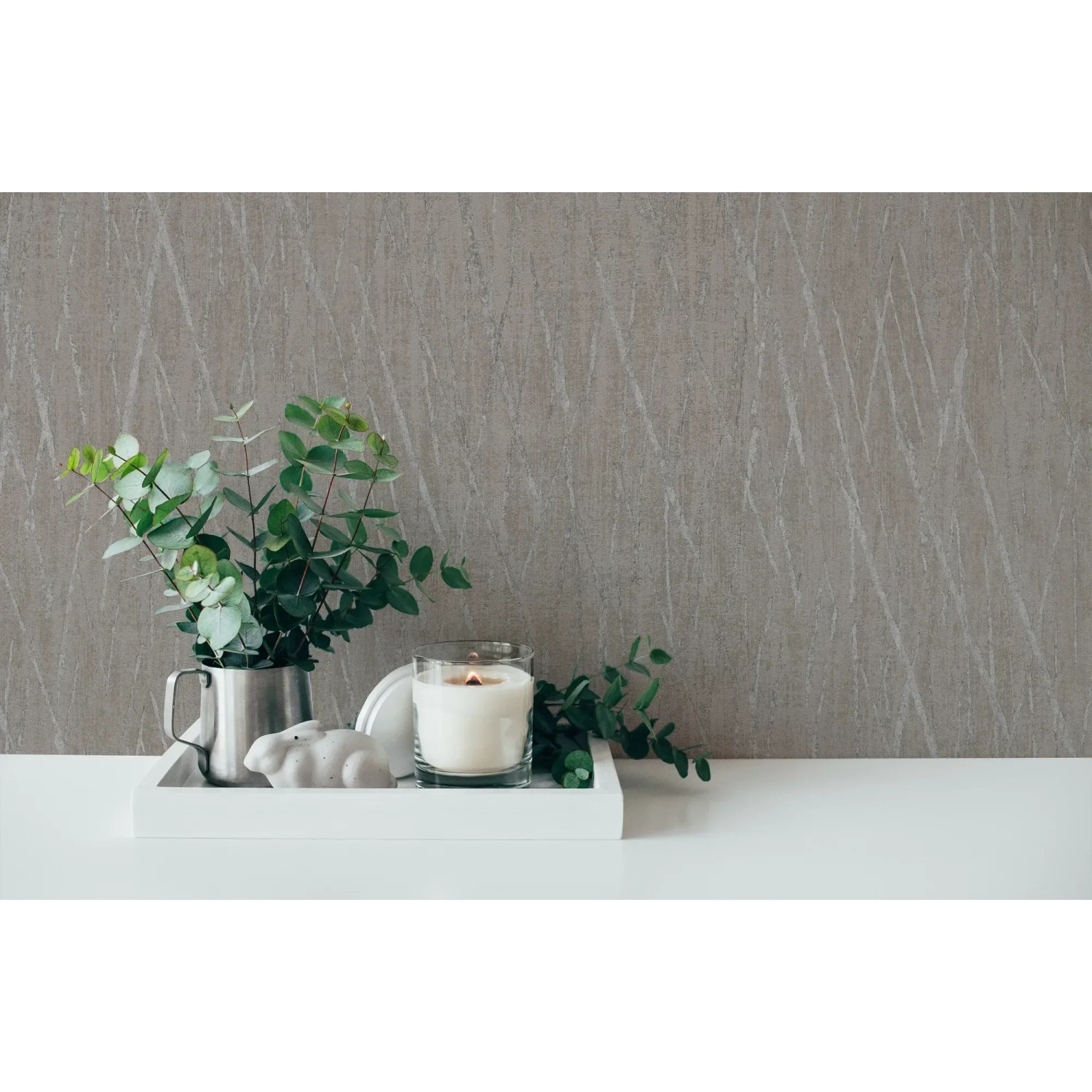Braune Vliestapete mit Metallic-Glanz und Strukturmuster, kombiniert mit Deko-Elementen.