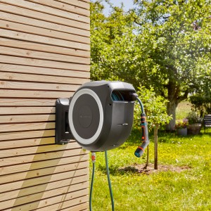 Gardena Wand-Schlauchbox XL mit Comfort Spritze am Holzhaus. Gartenschlauchwagen zur Gartenbewässerung.