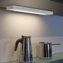 Weiße Trio LED Unterbauleuchte, 34 cm, montiert unter einem Schrank, beleuchtet eine Arbeitsfläche.
