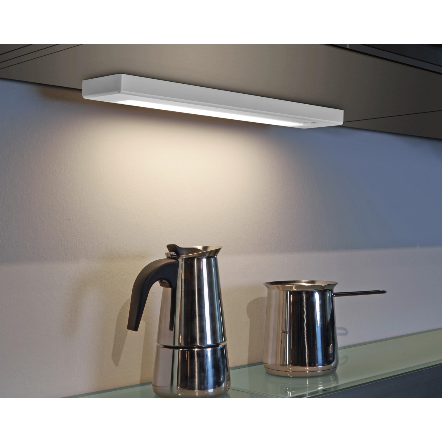 Weiße Trio LED Unterbauleuchte, 34 cm, montiert unter einem Schrank, beleuchtet eine Arbeitsfläche.