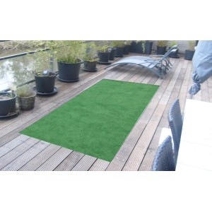 Grüner Kunstrasenteppich Green (100x200 cm) auf einer Holzterrasse im Außenbereich.