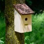 Nistkasten mit Rindendach aus Kiefernholz am Baum befestigt.