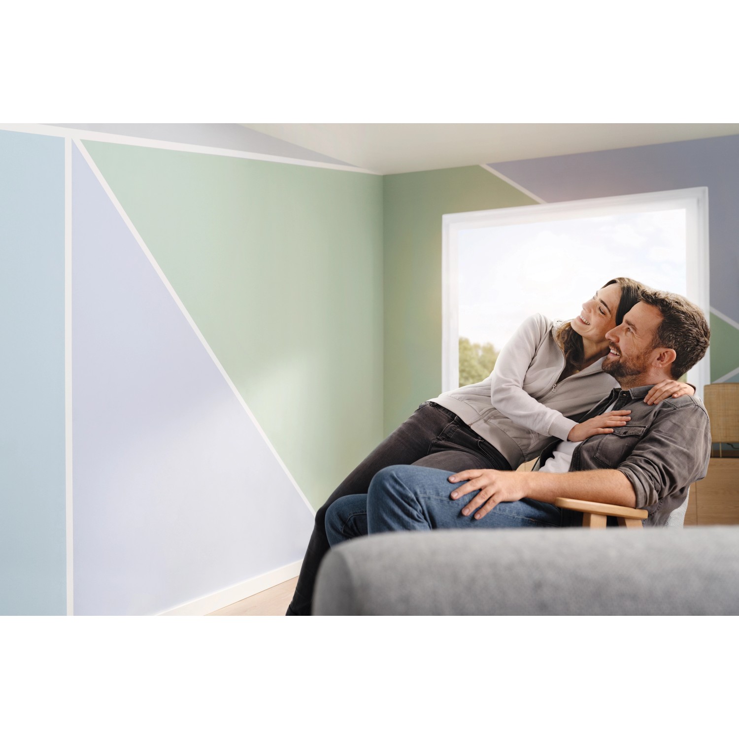 tesa® Malerband Perfect+ im Einsatz: Paar freut sich über farbige Wandgestaltung mit scharfen Farbkanten.