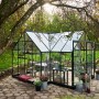 Halls Gewächshaus Garden Room, 12,9 m², grüne Aluminiumstruktur mit Sicherheitsglas im Garten.