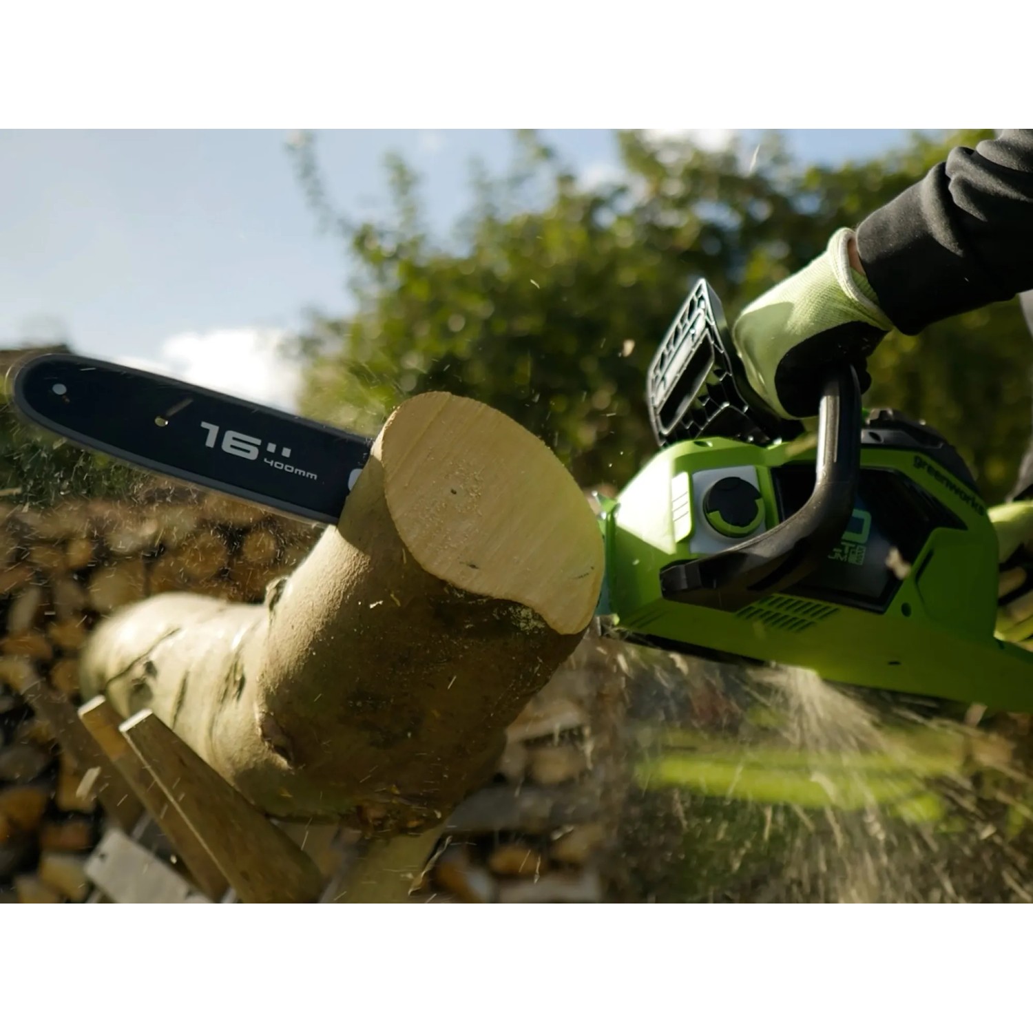 Greenworks Akku-Kettensäge GD40CS18 beim Sägen von Holz. Die Kettensäge ist grün und schwarz.