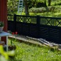 Schwarzer Vorgartenzaun Nostalgi aus Nadelholz, 180x95 cm, im Garten mit Leiter.