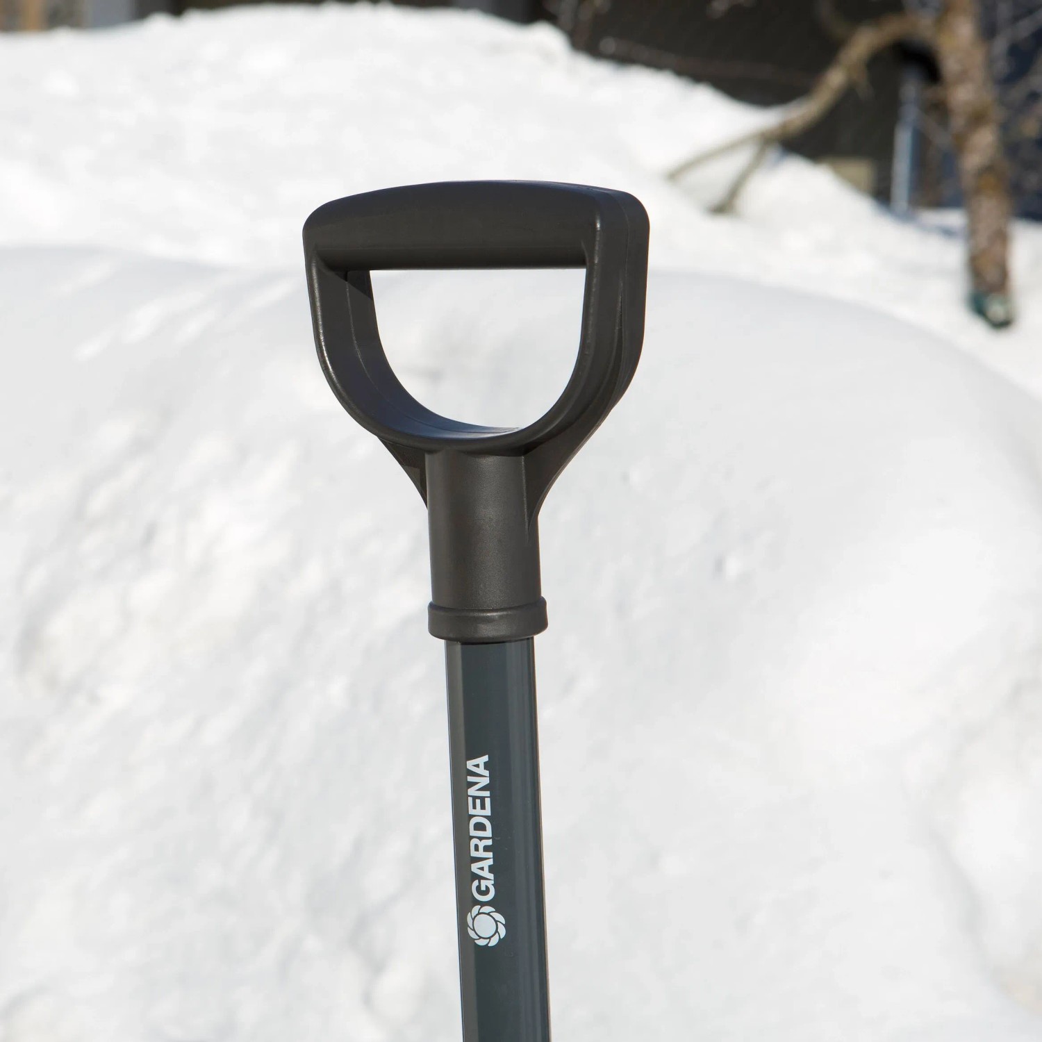 Detailaufnahme: Griff der Gardena ClassicLine Schneeschieber vor Schneehaufen.