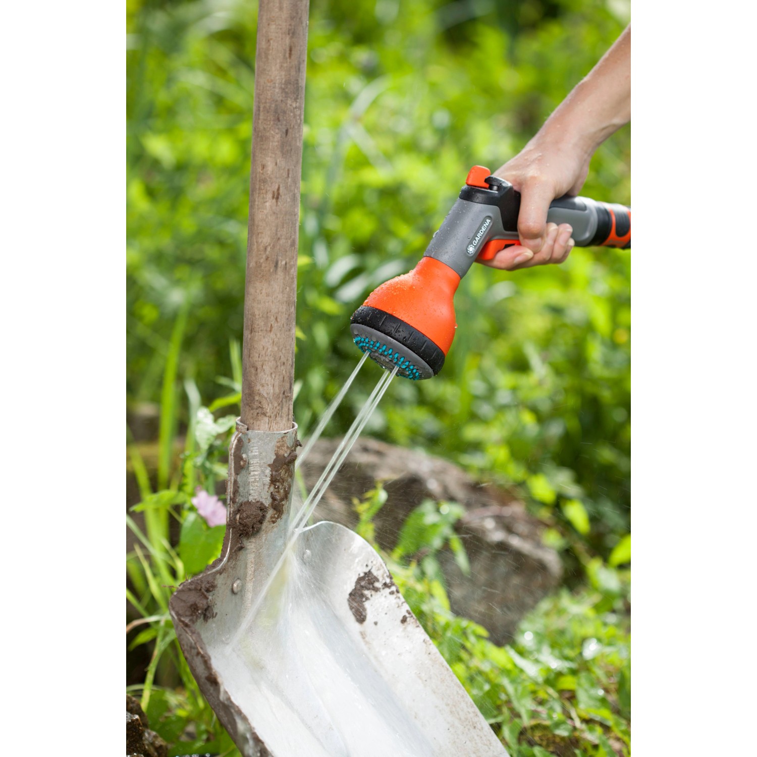 Gardena Classic Multibrause in Aktion: Bewässerung und Reinigung einer Schaufel im Garten.
