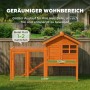 PawHut Kaninchenstall aus orangefarbenem Tannenholz mit großem Drahtauslauf und wetterfestem Dach im Garten.