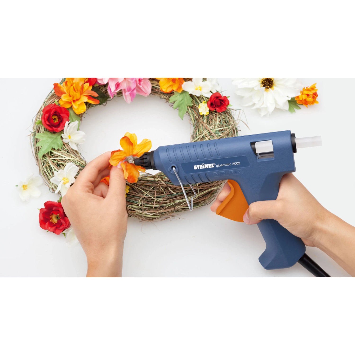 Steinel Heißklebepistole mit Cristal Klebesticks beim Basteln eines Blumenkranzes.