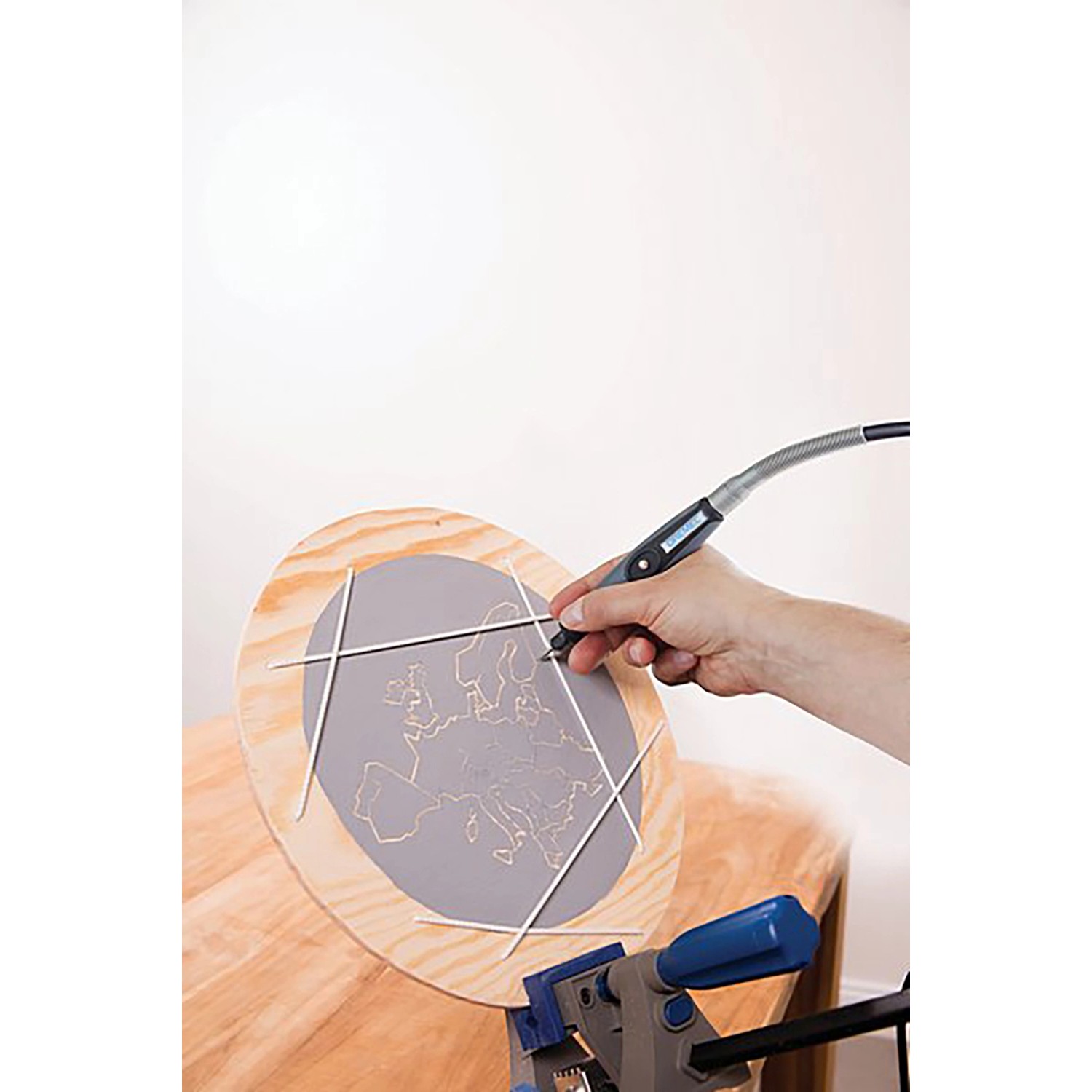 Dremel Holzbearbeitungs-Set in Aktion: Hand graviert Europa-Karte in Holzscheibe mit Miniaturwerkzeug.