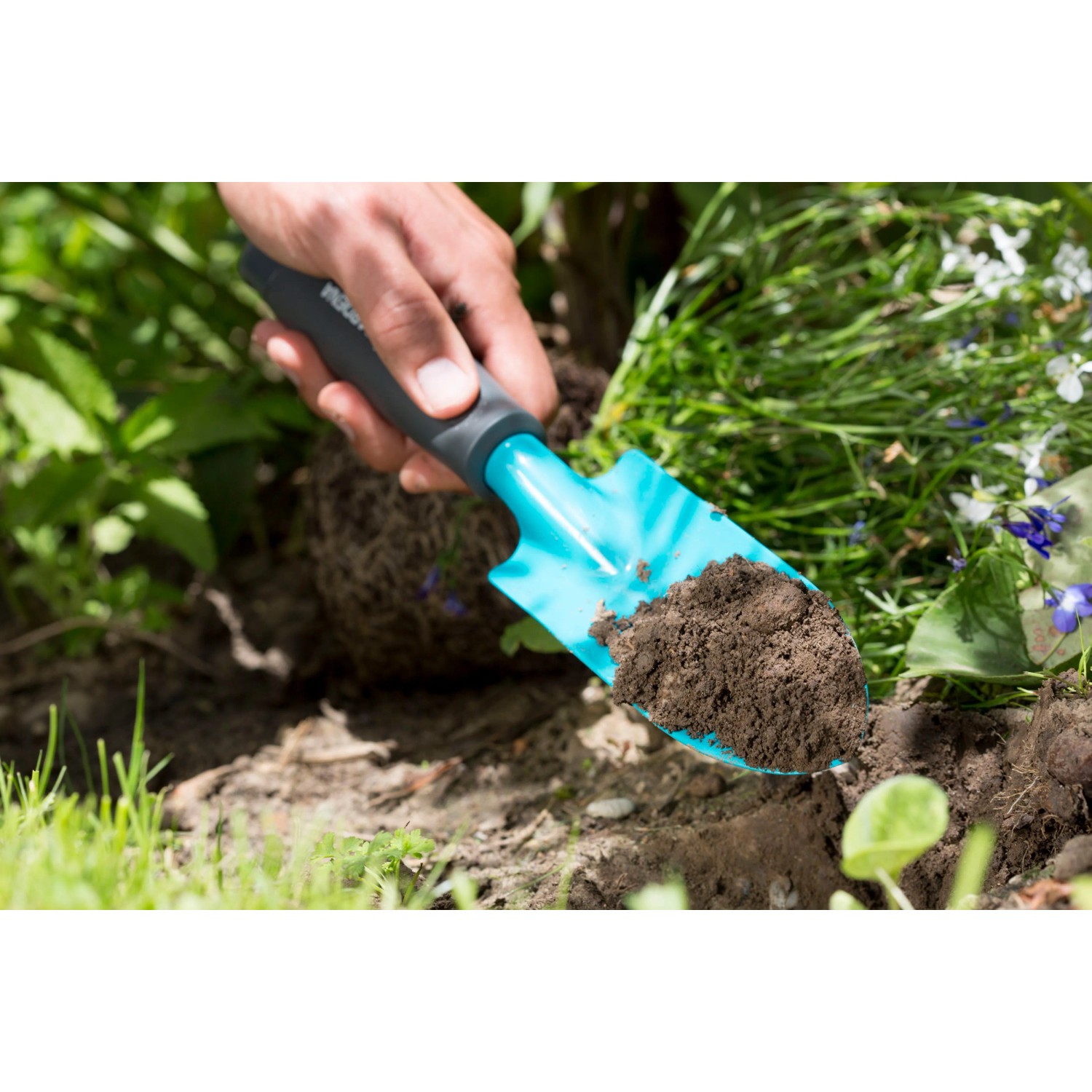 Gardena Blumenkelle Classic im Einsatz mit Erde. Gartenhandgerät mit ergonomischem Griff.