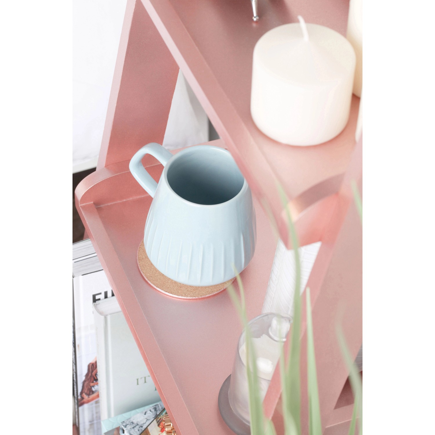 Dekoratives Regal mit Roségold Metallic Spray behandelt, mit Tasse und Kerze dekoriert.