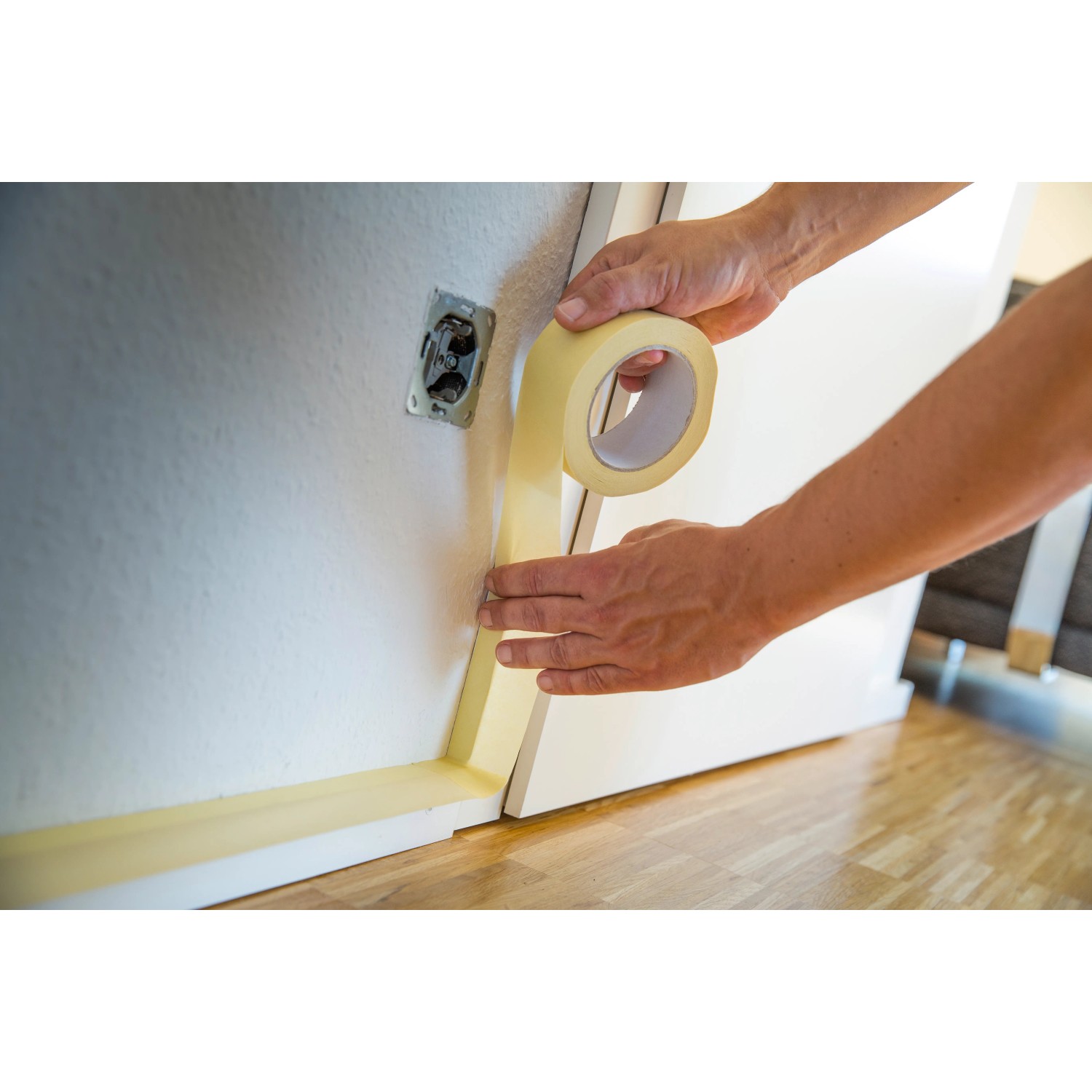 Anwendung von LUX Flachkrepp Klebeband (50mm) zum Abkleben einer Türzarge.