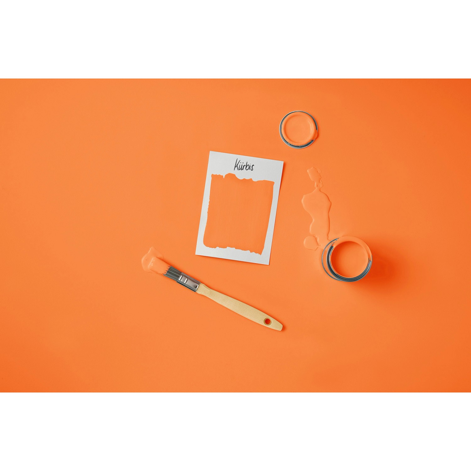 Rust-Oleum Kreidefarbe Kürbis: Dose, Farbfleck, Pinsel auf orangefarbenem Grund.