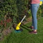 Frau trimmt Rasen mit gelbem Kärcher Akku-Rasentrimmer LTR 18-30. Akku-Trimmer für präzise Rasenkanten.