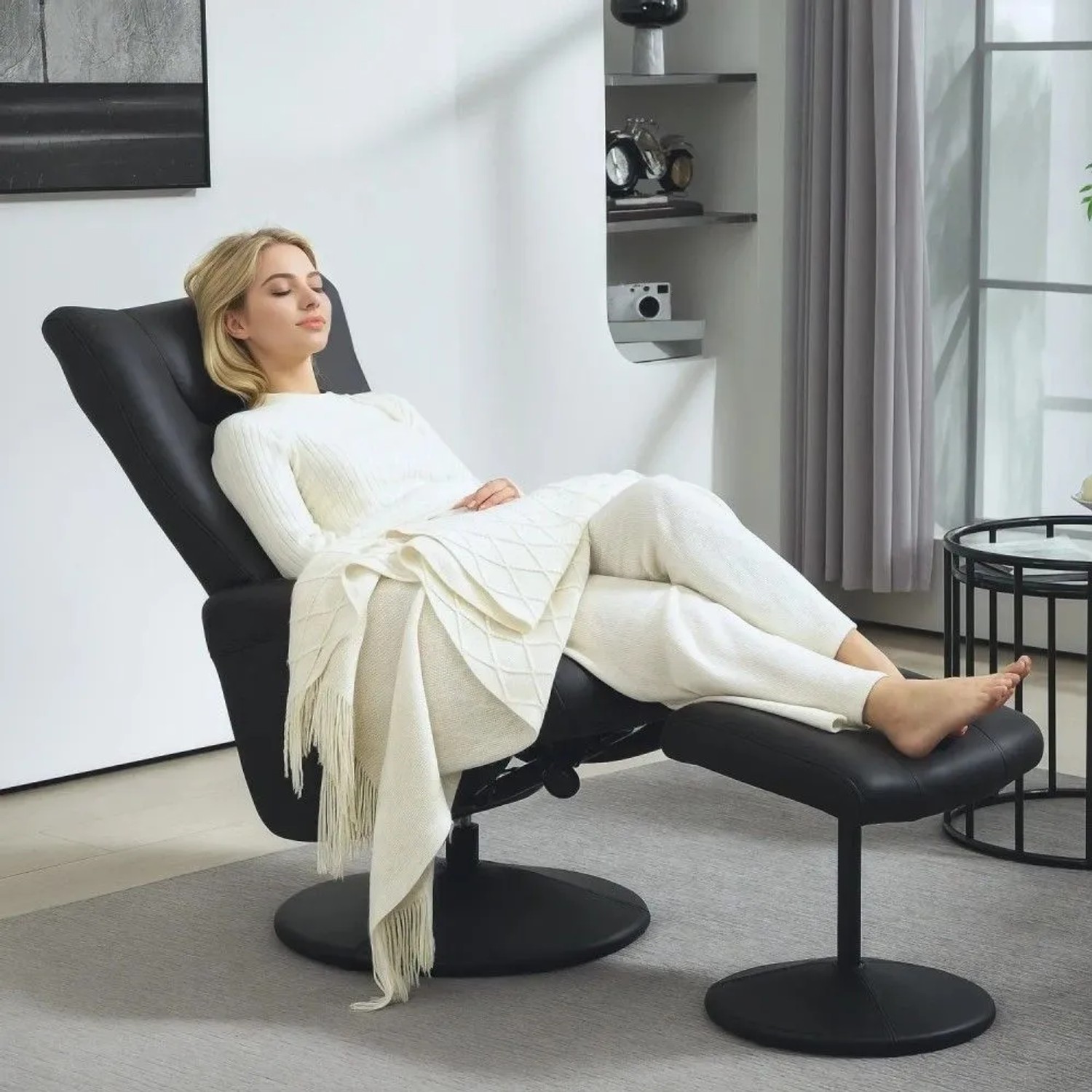 Schwarzer HOMCOM Relaxsessel aus Kunstleder mit Hocker, in dem eine Frau entspannt liegt. Ideal für Loungesessel.