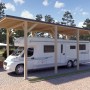 Holzbrüder Camping-Carport Ralf Natur mit dunkelgrauem Blechdach und Wohnmobil.