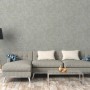 Blau strukturierte Vliestapete Uni Matt FSC® an Wand hinter Sofa und Lampe.